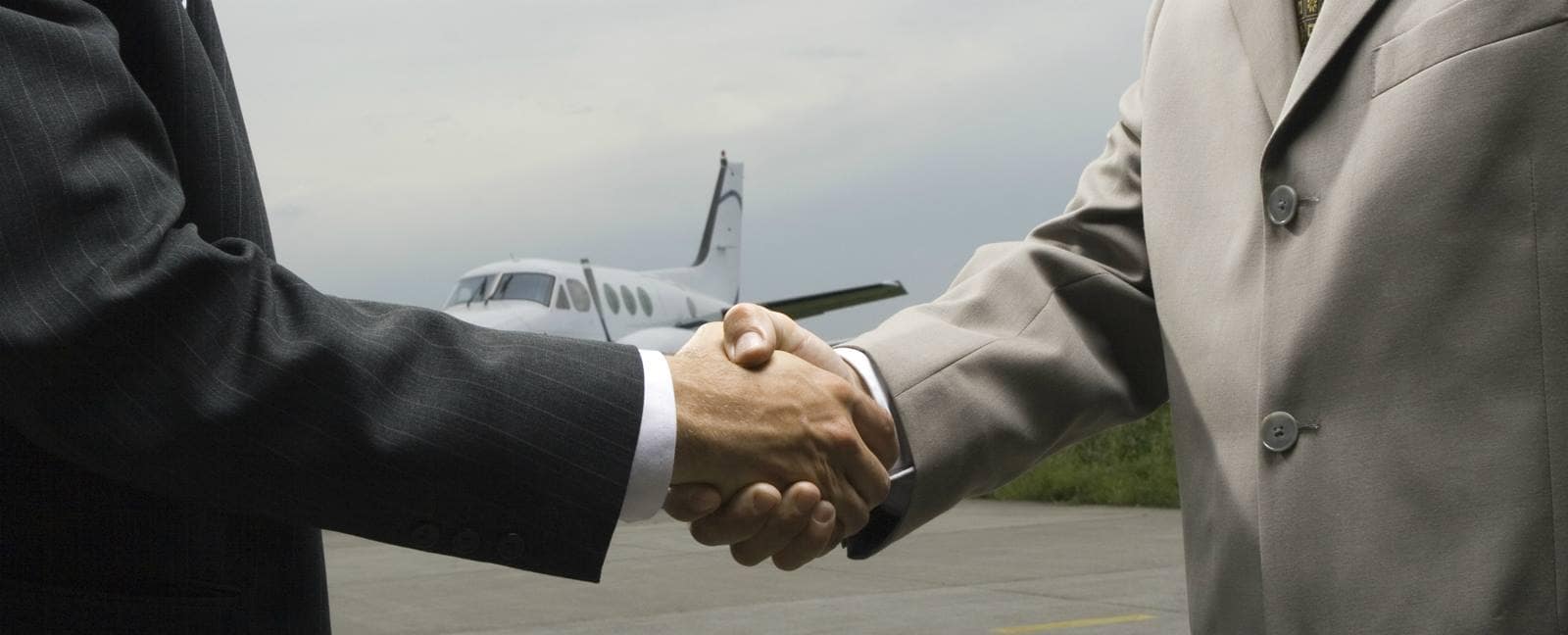two men shaking hands at an airport