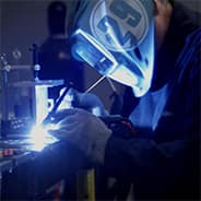 a student welds in the axfab lab