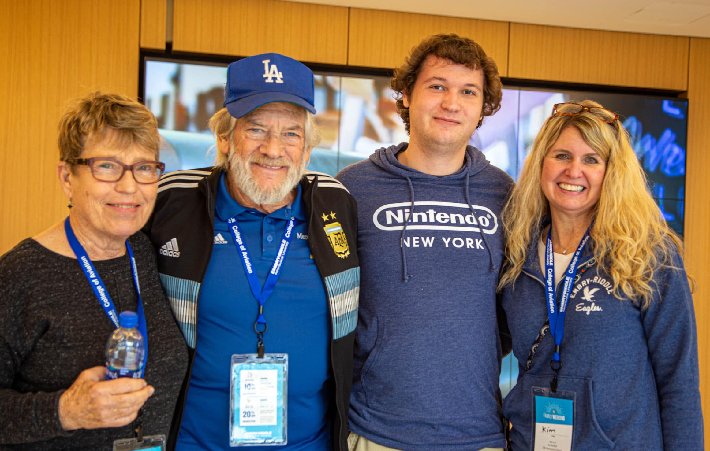 A family poses with their arms around each other, wearing lanyards with their Family Weekend IDs.