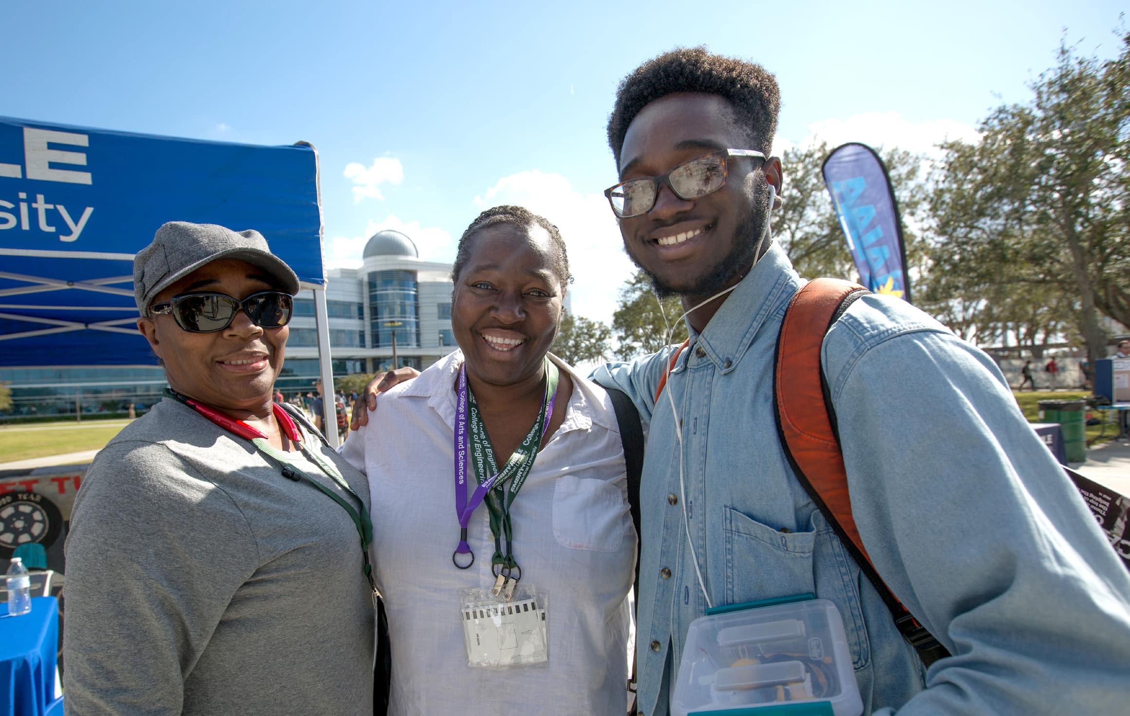A family outside at Prescott Family Weekend, posing with their arms around each other.