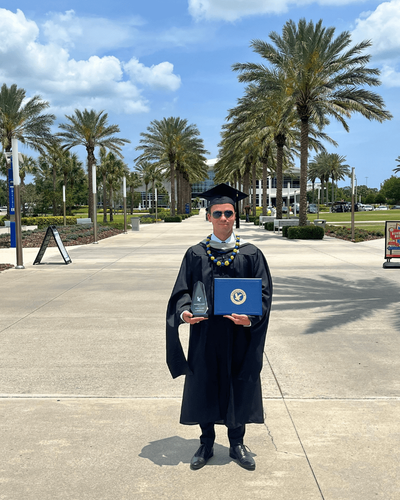 Victor on campus with his diploma.