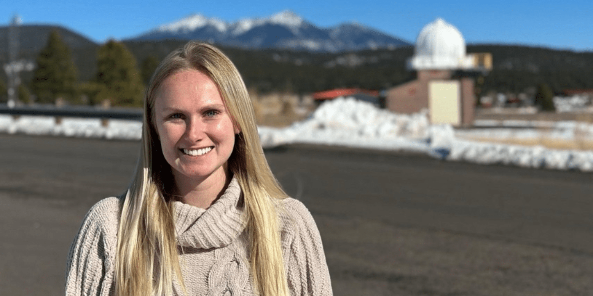 Paige Konieszny smiling, outdoors in a sweater.