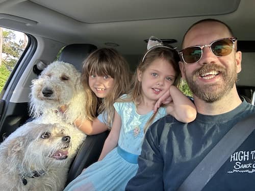 Andrew with two young daughters and two dogs