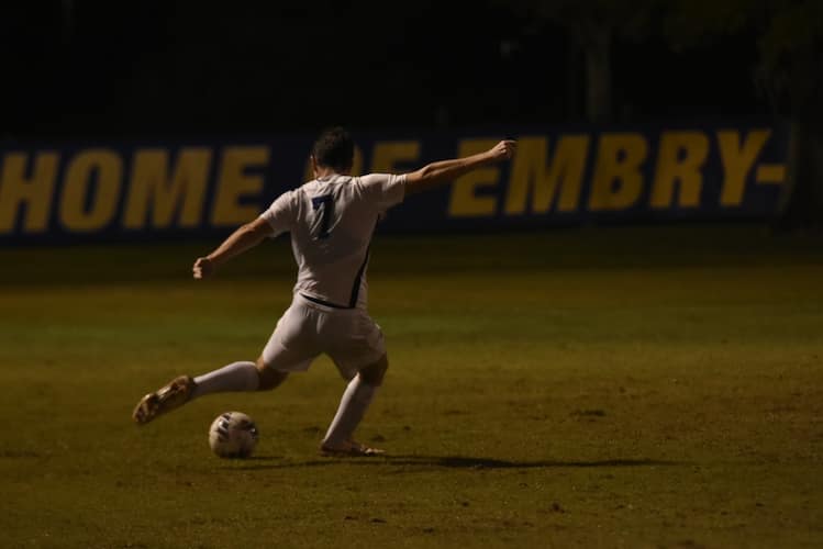 Louis Walker kicking a soccer ball during a game