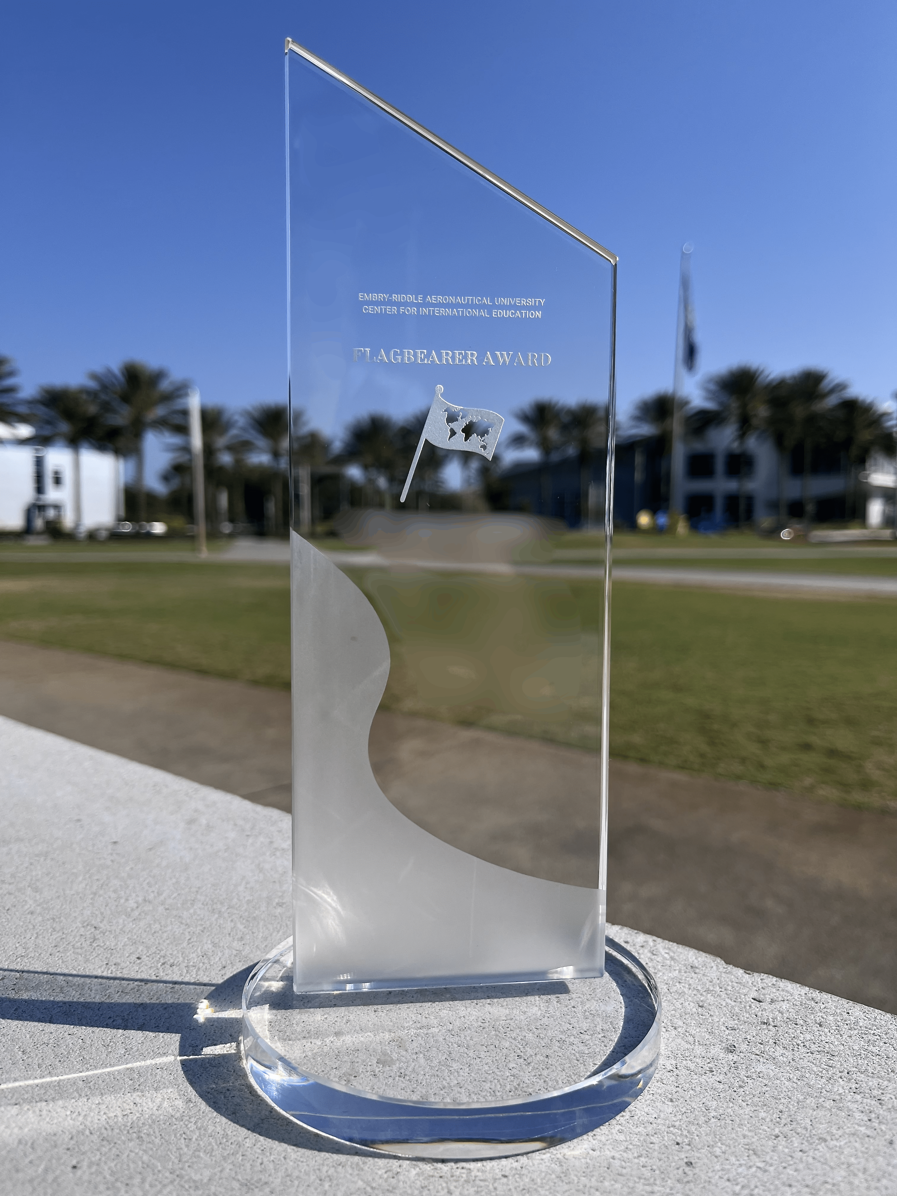 A glass award sitting on a wall outside.