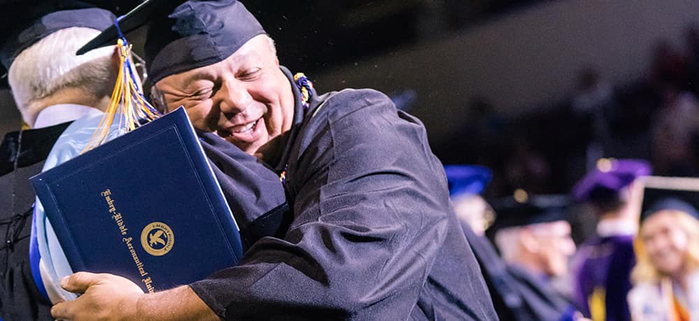 An excited Embry-Riddle student receiving his diploma at graduation