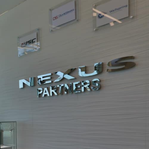 a sign with letters on a wall reading Nexus Partners