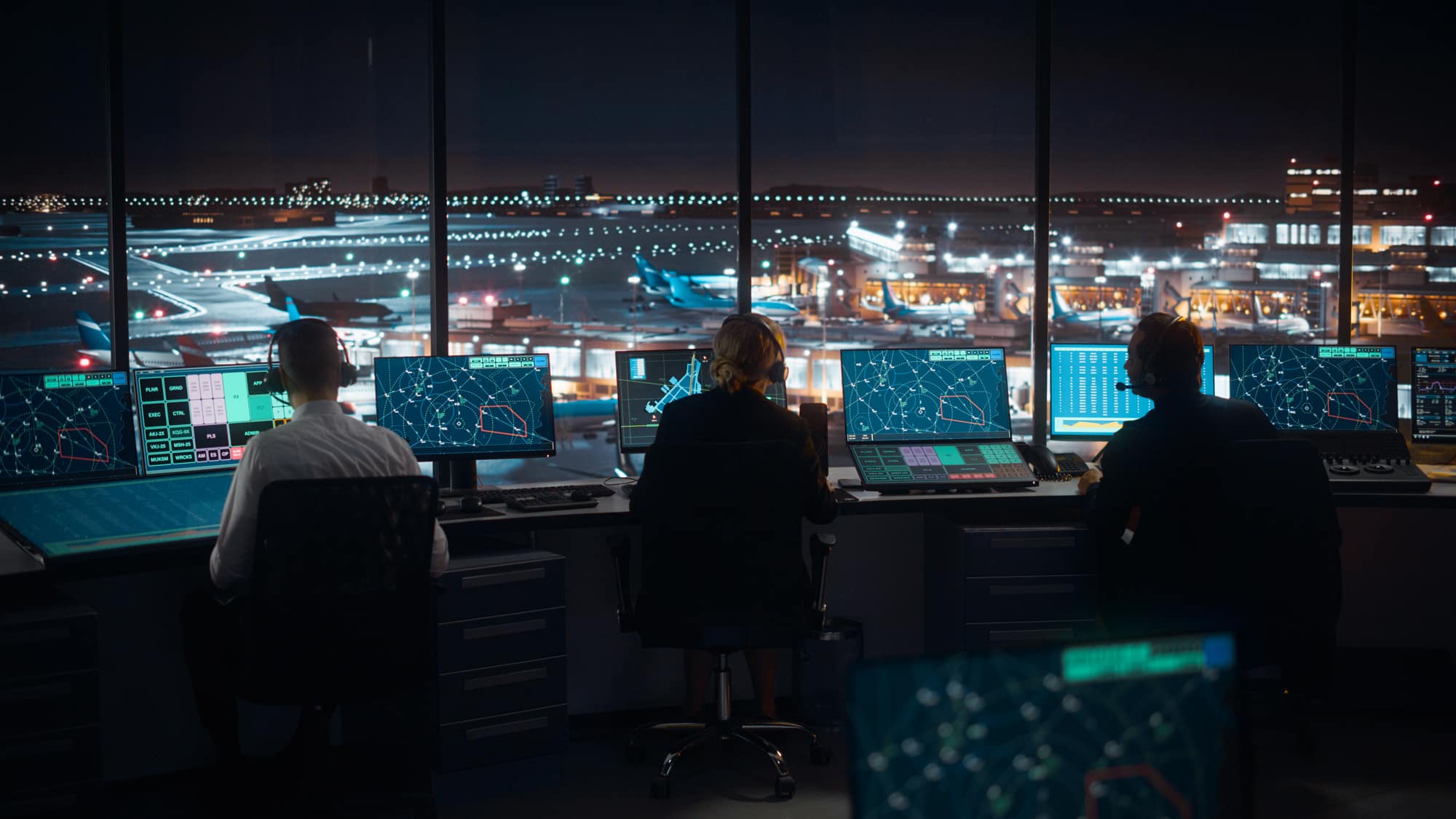 Air traffic controllers working at an airport at night