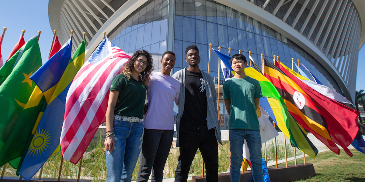 students stand with flags outside the student union