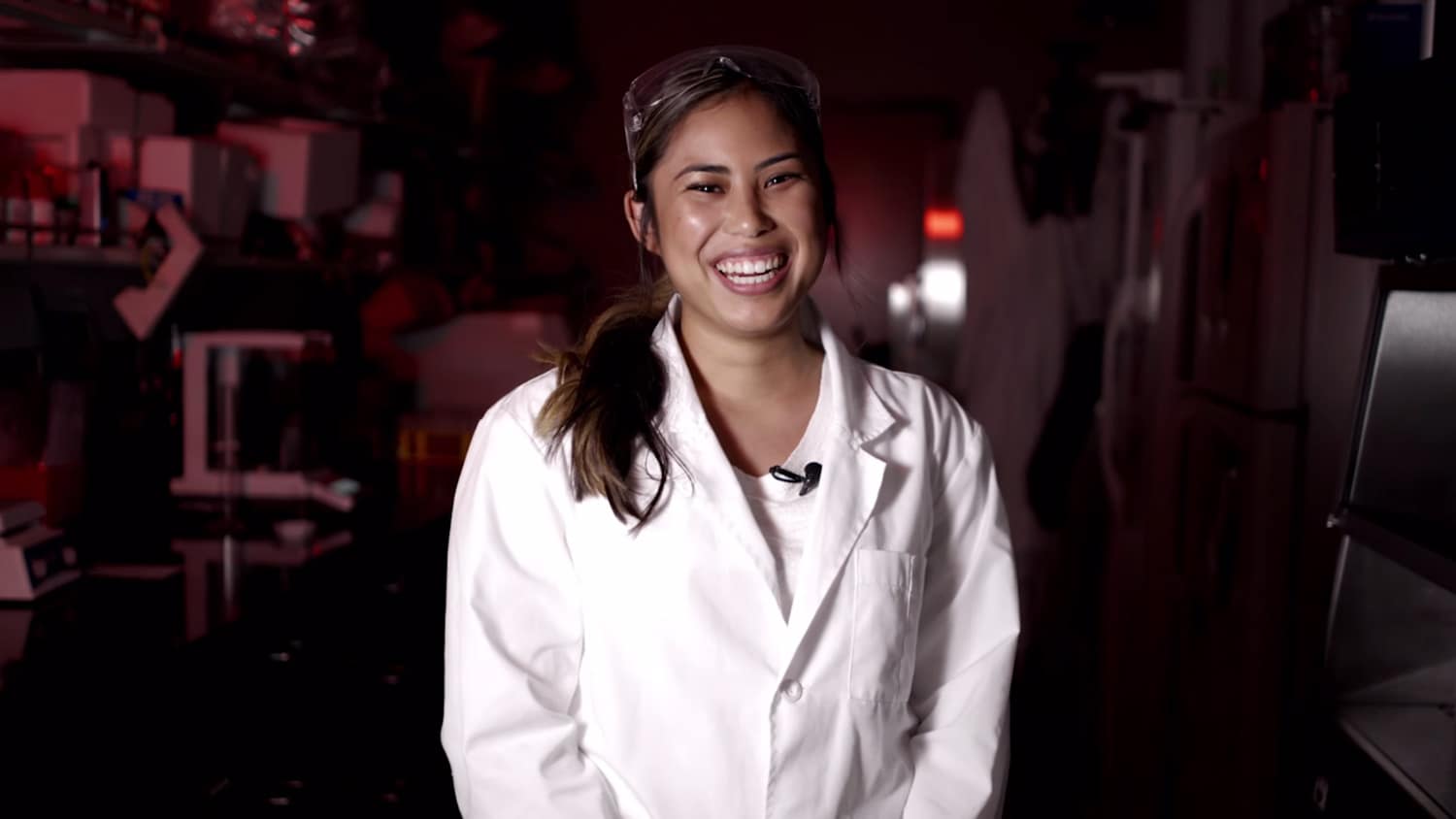 Embry-Riddle student Nina Egbalic stands in a lab in a white lab coat.