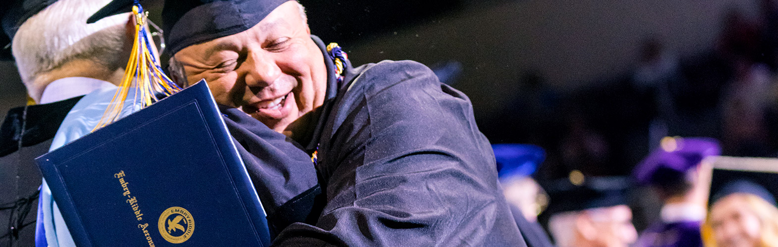 An excited Embry-Riddle student receiving his diploma at graduation